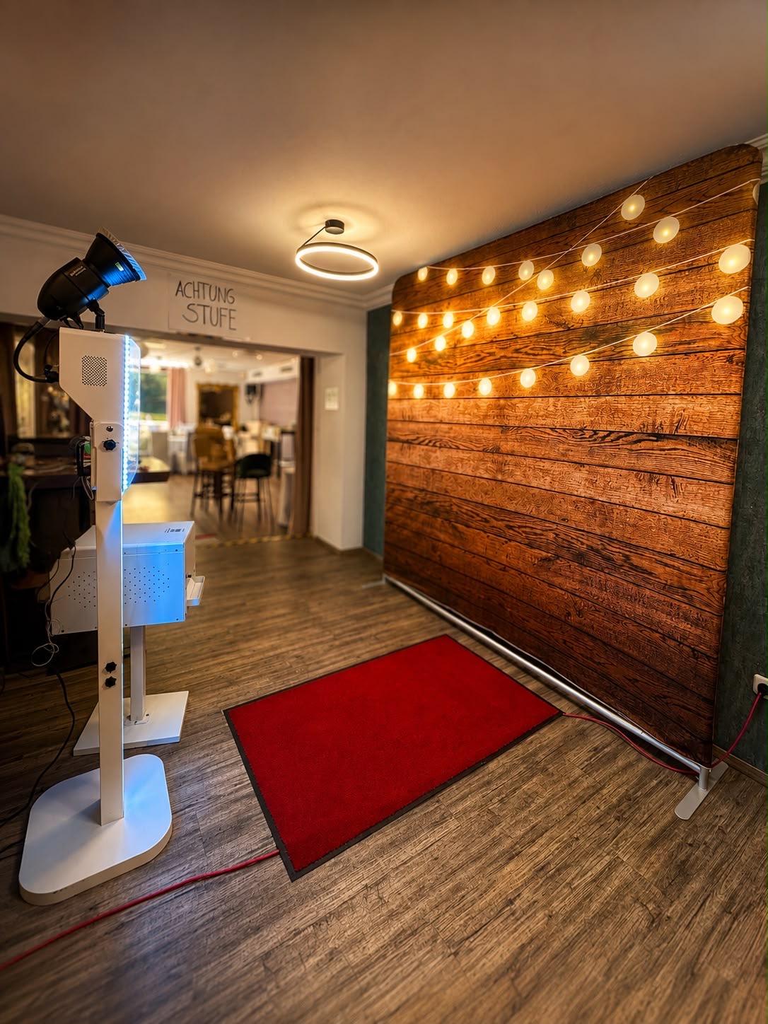 Fotobox mit Studioblitz vor Holz-Hintergrund mit Lichterkette bei einer Hochzeit im Restaurant See Bar in Essen